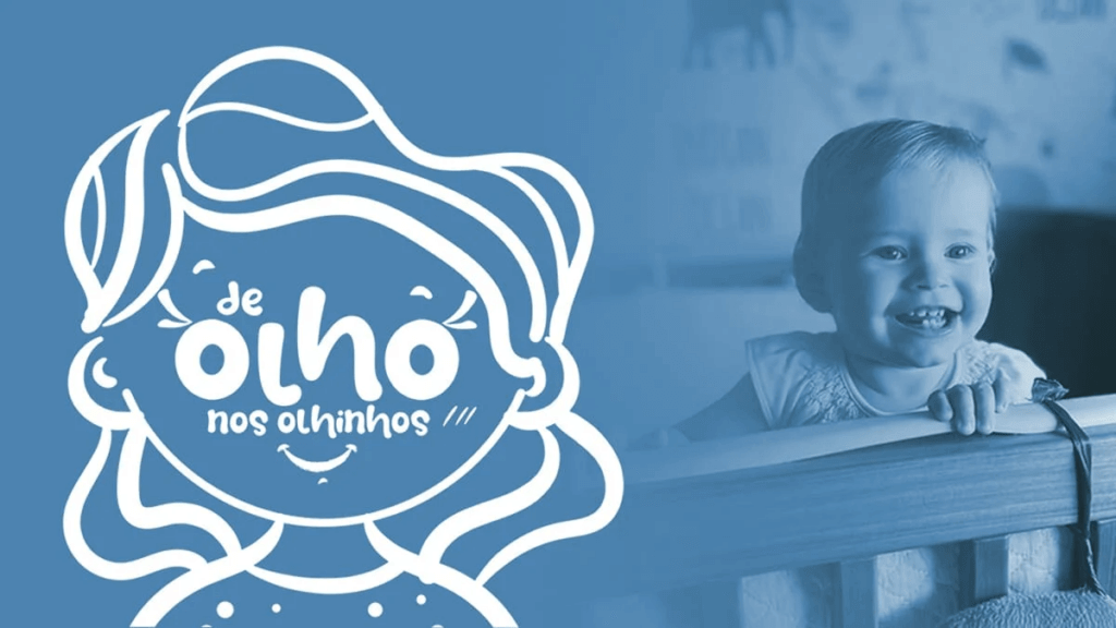 Ilustração com fundo azul contendo o desenho estilizado de uma criança sorridente com a frase "de olho nos olhinhos" escrita no rosto. Ao lado direito, uma criança real loira sorri encostada em uma grade de berço, também em tom azul, transmitindo alegria e saúde visual infantil.