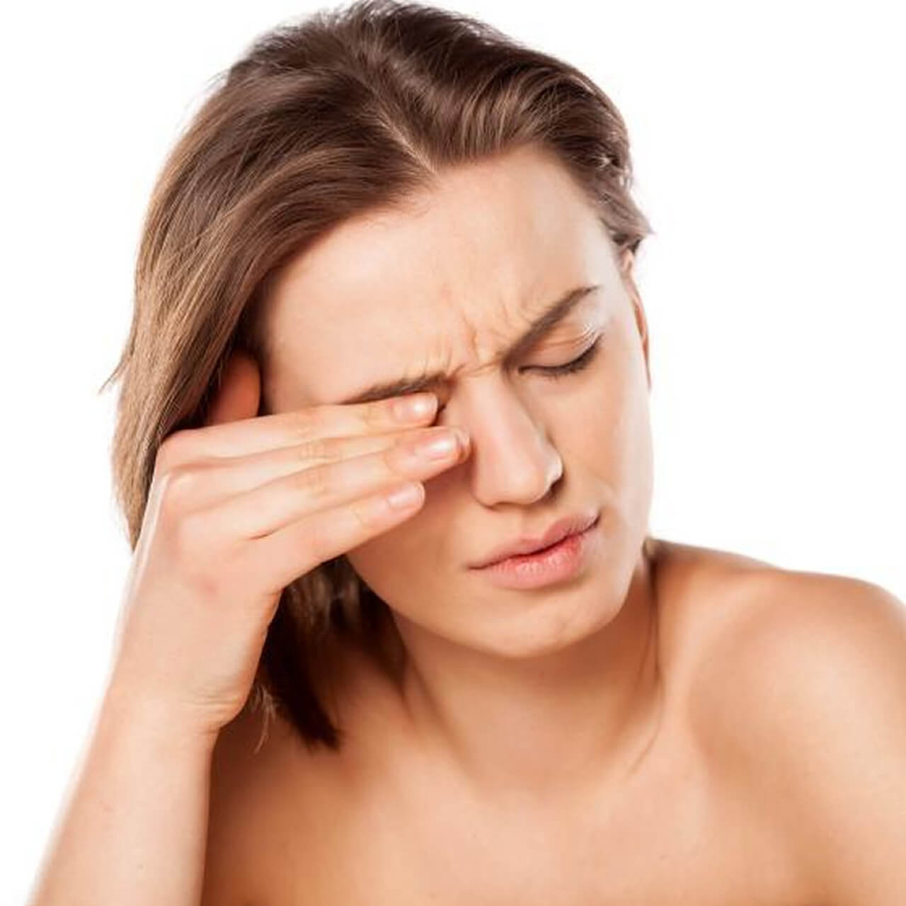 A imagem mostra uma mulher com uma expressão de desconforto, segurando a testa com uma das mãos, como se estivesse sentindo dor ou pressão nos olhos. Ela parece estar lidando com algum tipo de dor ocular ou cefaleia. O fundo é neutro e a mulher está sem roupa, indicando que a atenção está totalmente voltada para a expressão de dor ou desconforto.
